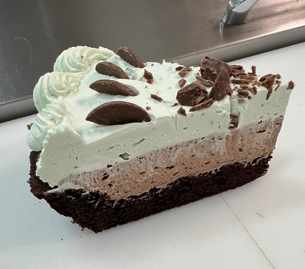 A tall slice of mint chocolate mousse pie with chocolate shavings
